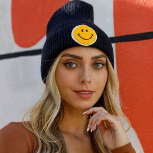 Black knit beanie with a yellow smiley face patch